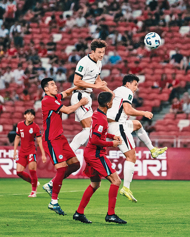 港队前锋安永佳（中）头槌攻门。