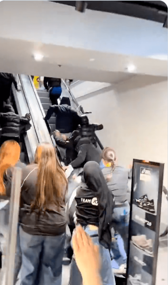 當歹徒企圖沿扶手電梯逃跑時，女店員們在移動的電梯上與他們發生肢體衝突，奮力扯下對方手中的衣物。