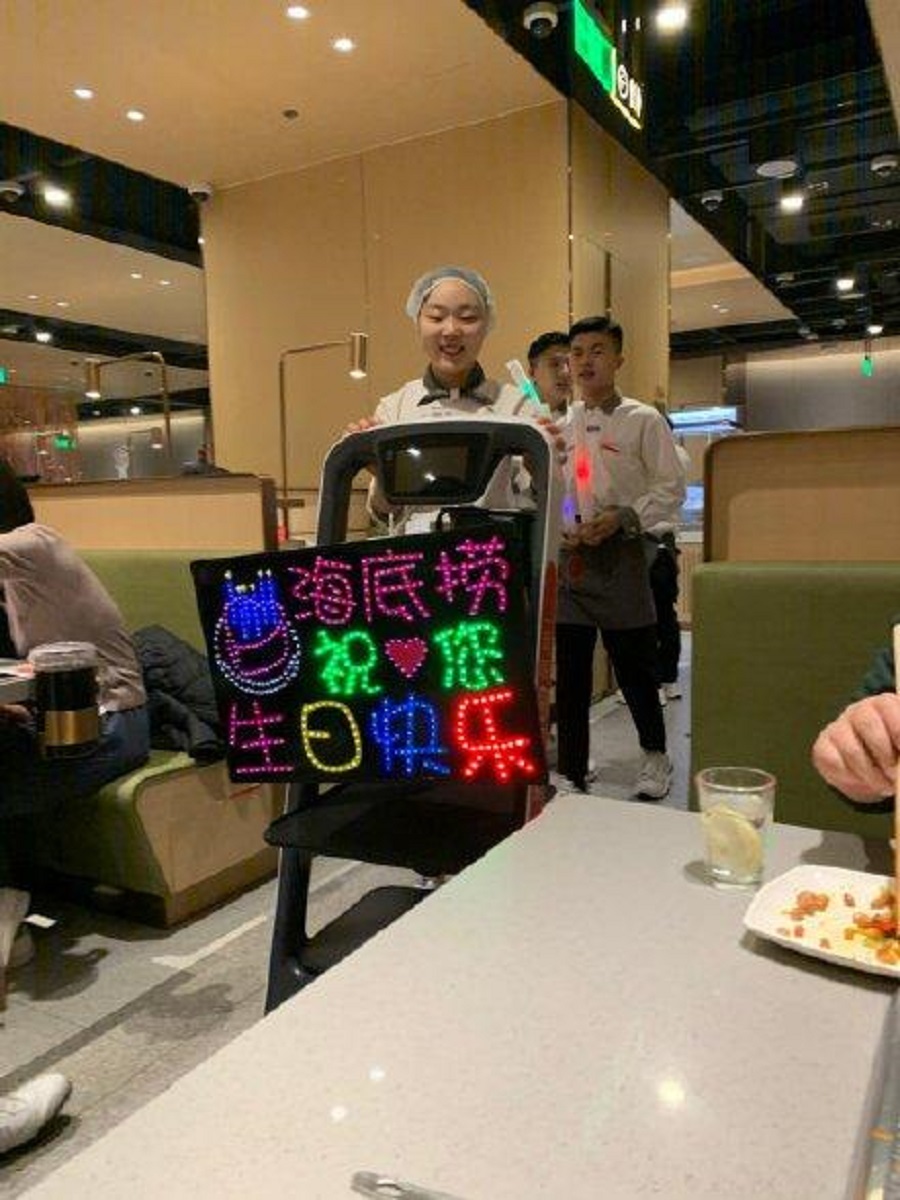 在海底撈過生日會有職員熱情地舉牌唱歌。網上圖片