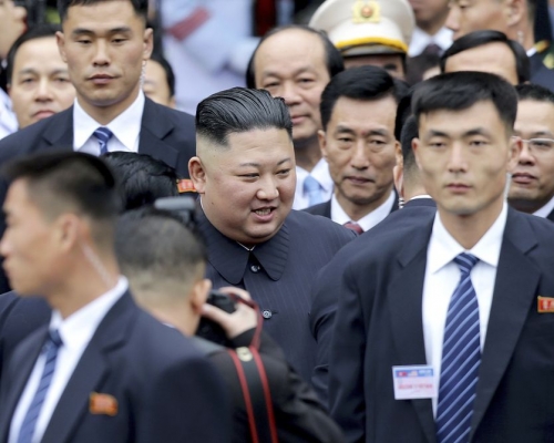 金正恩步出車站,面帶笑容。AP