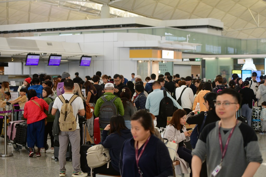 大批旅客排队等候办理登机手续。欧乐年摄