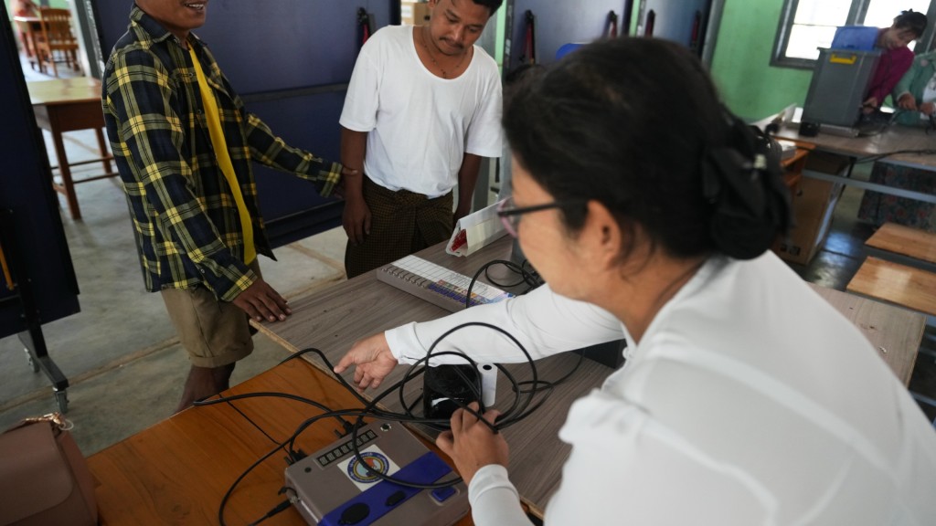 緬甸大選｜選委會職員及義工在仰光一個票站測試電子投票機。 美聯社