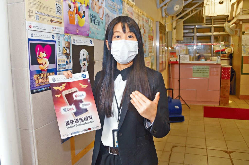 署理警民關係主任梁燕喬展示在區內公屋張貼的防騙宣傳海報。