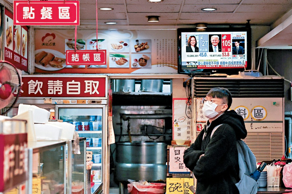 特朗普競選期間暗示無意軍事協防台灣。圖為一名台北市民關注美國大選新聞。