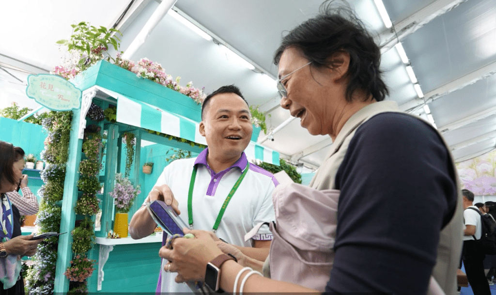 國安處處長江學禮在花卉展內向巿民派發國安紀念品。