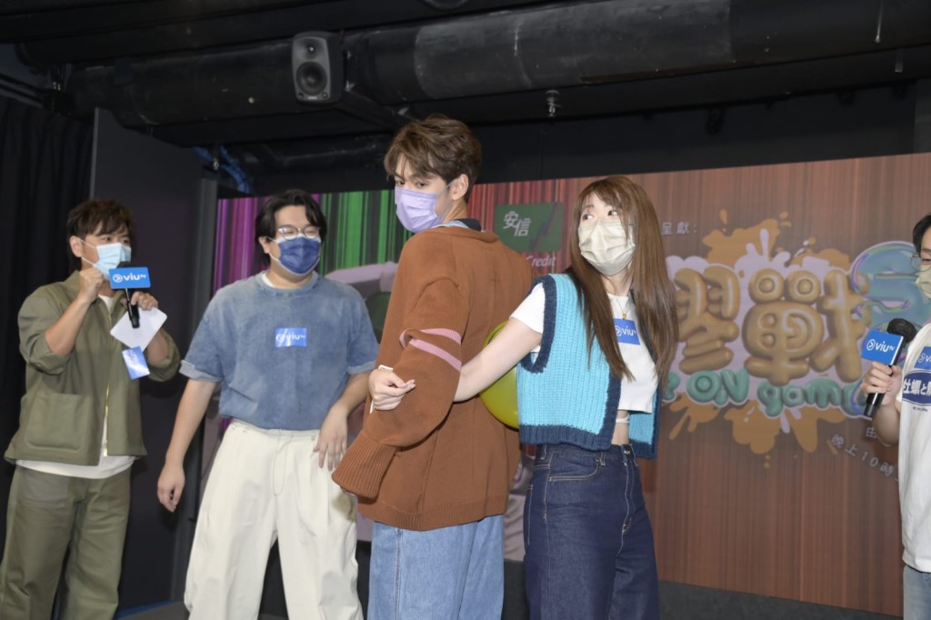 Jeffrey和Hillary用背脊夾氣球。