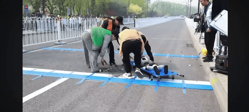 工作人員用擔架將機械人抬走。