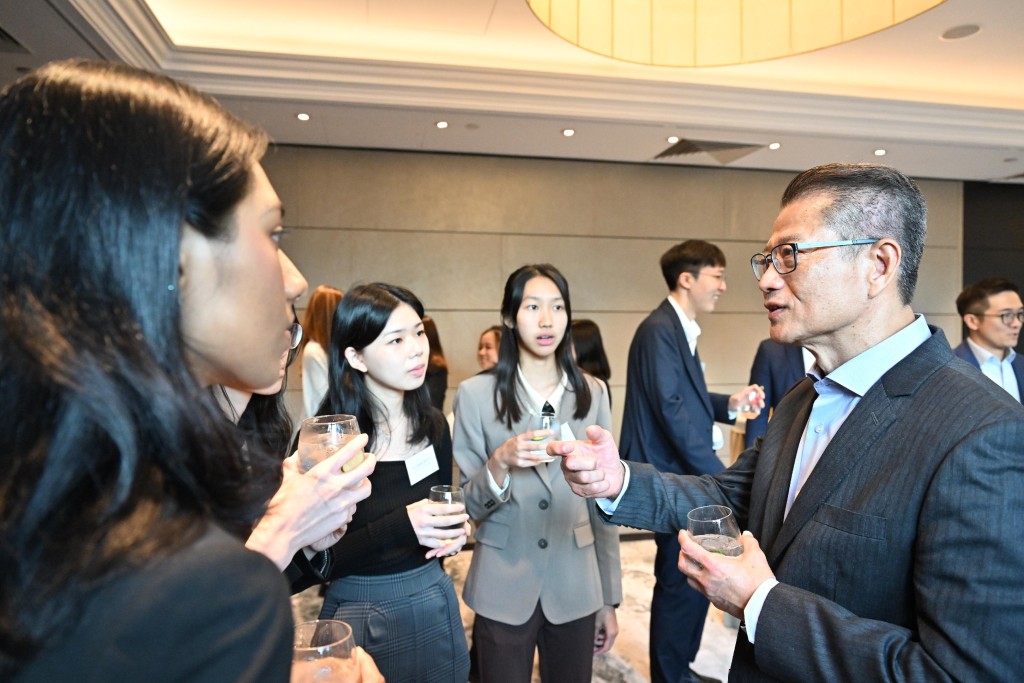 陳茂波與一批獲教育局香港卓越獎學金計劃資助的在英留學生會面。政府新聞處
