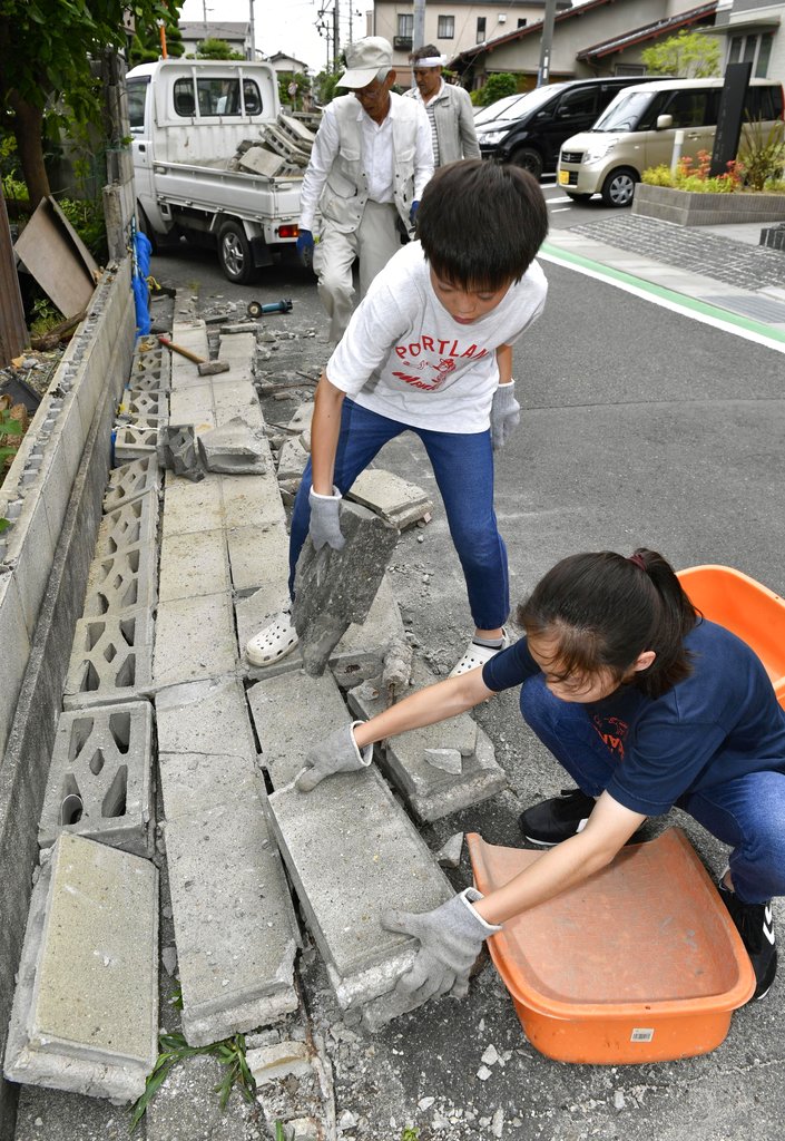 民眾清理地震瓦礫。AP圖片