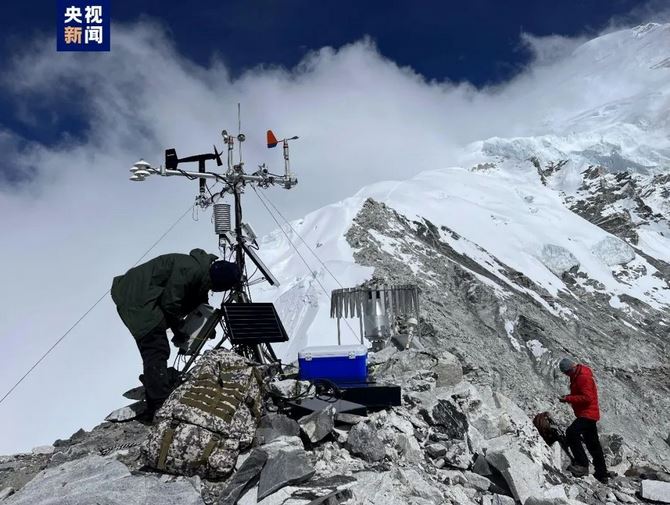 科考队员在山顶架设科学设备。央视截图