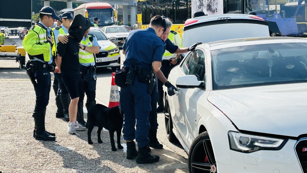 男司機被黑布蒙頭，警方出動緝毒犬搜車。