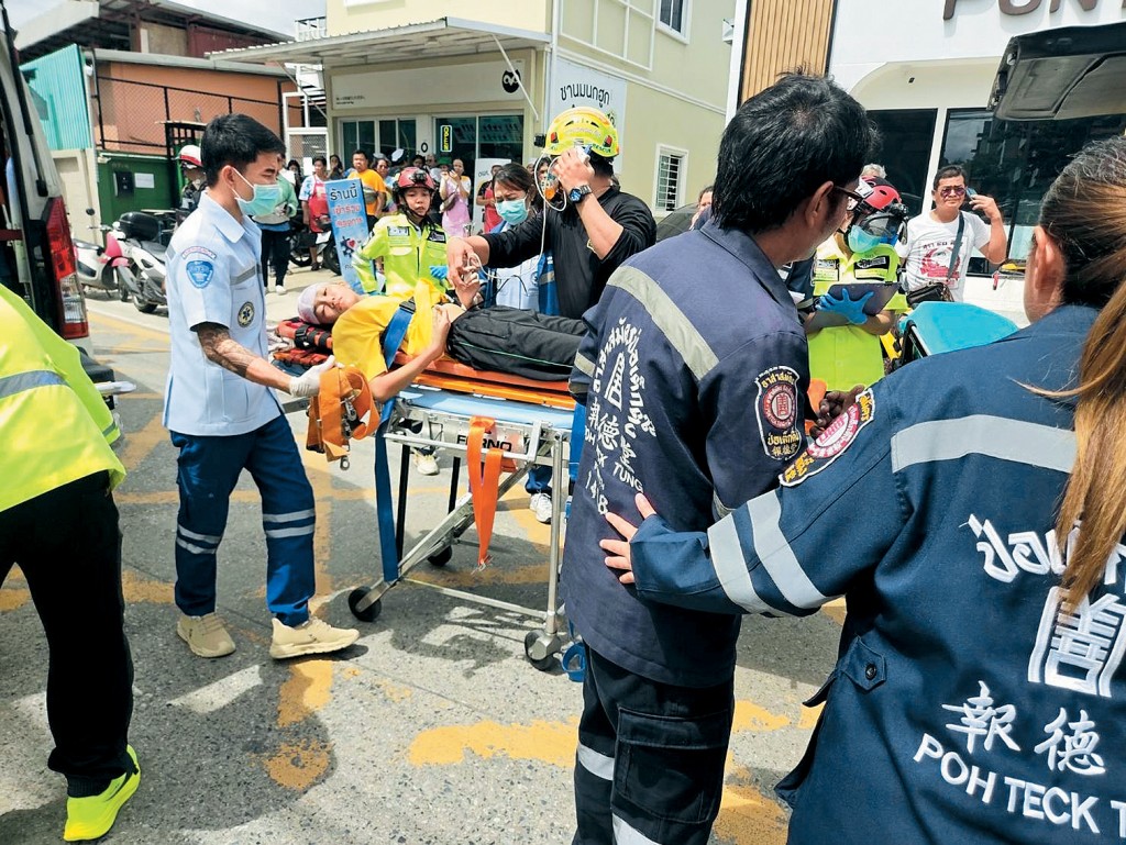 救援人员在学校内用担架抬走伤者。