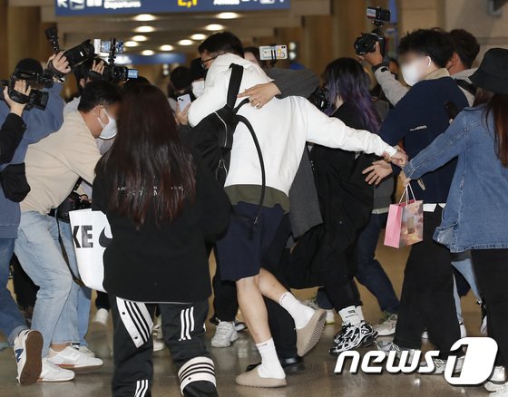 金宣虎离开机场时差点被人拉跌。