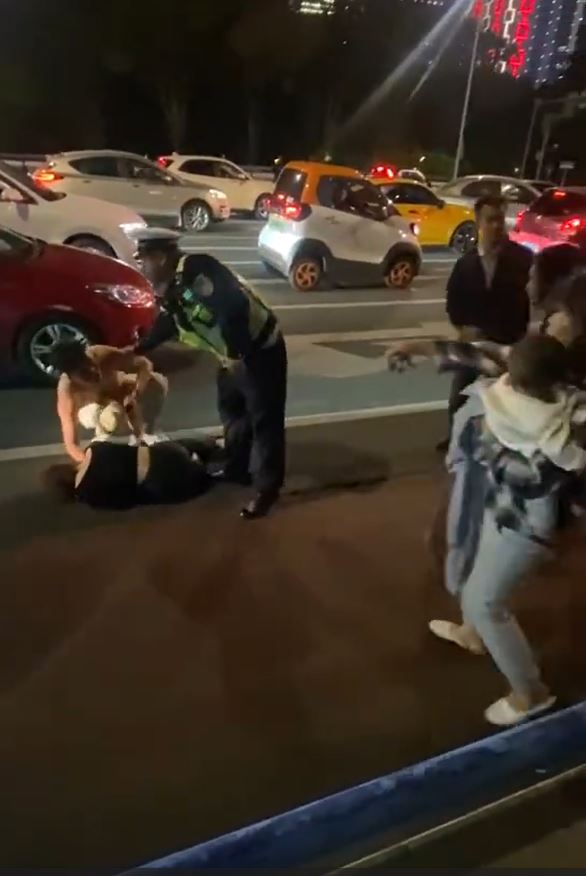 广西有男女因驾驶爆街头冲突，最终男子被女方咬甩背部一块肉。影片截图
