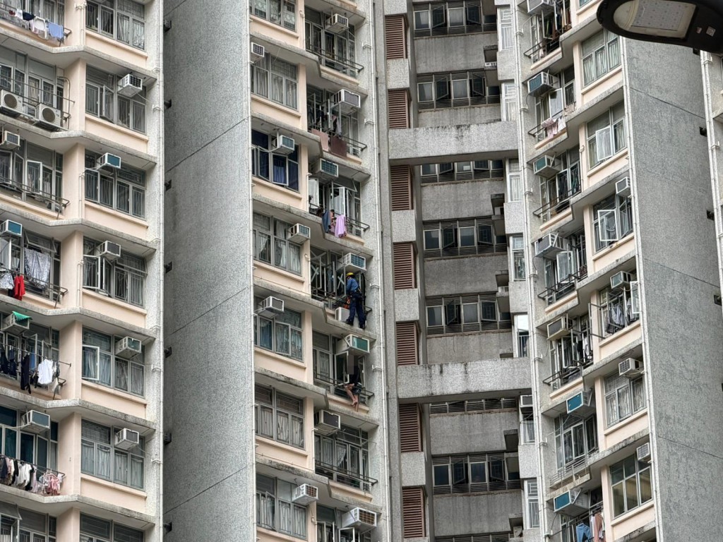 一名19歲青年危坐在窗邊簷篷的晾衫架上,險象環生。 一名19歲青年危坐在窗邊簷篷的晾衫架上,險象環生。