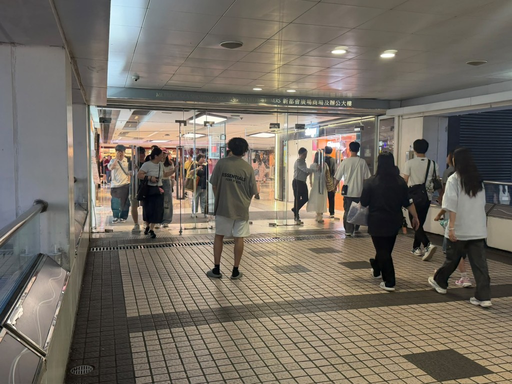 二手書店年輕員工在連接新都會廣場的天橋上遞卡片拉客。 二手書店年輕員工在連接新都會廣場的天橋上遞卡片拉客。