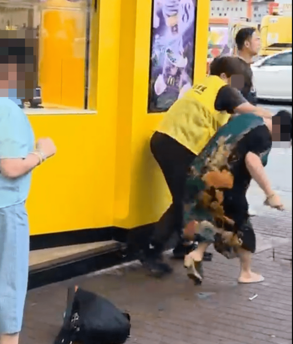 身穿黃色背心女子上前動手,抓住對方頭髮並將其扯跌在地。Threads@okkelvin 影片截圖 身穿黃色背心女子上前動手,抓住對方頭髮並將其扯跌在地。Threads@okkelvin 影片截圖