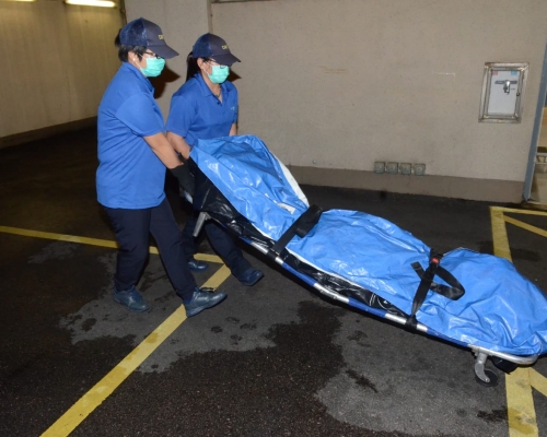 死者遺體由仵工舁送殮房。