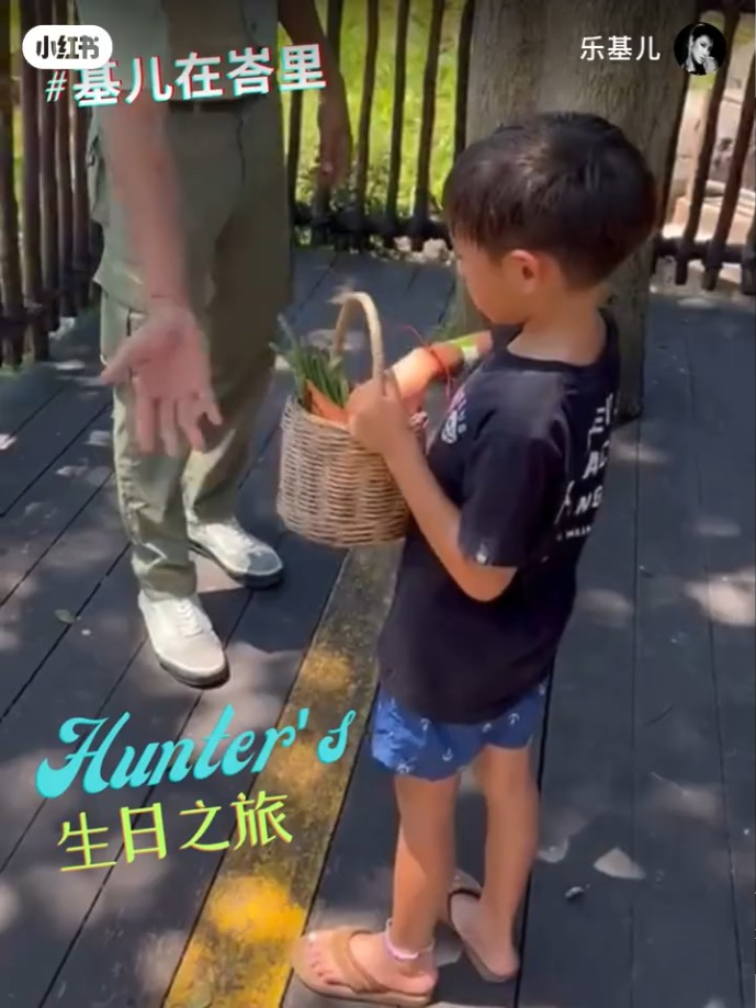 Hunter從動物園的工作人員手上接過一籃紅蘿蔔。