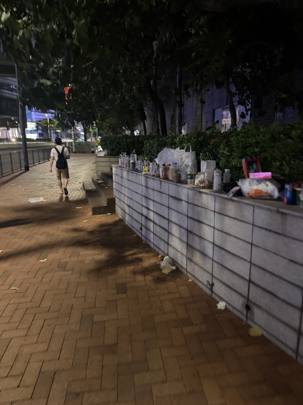 尖沙咀文化中心行人路旁的石壆矮牆上堆滿大量飲品杯與外賣廢棄物。Threads圖片