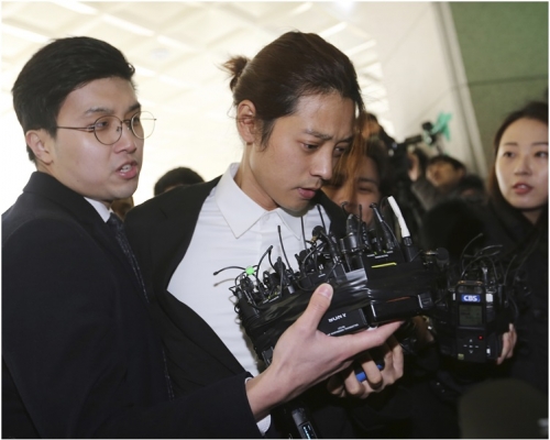 鄭俊英身穿黑西裝憔悴現身首爾地方警察局。AP