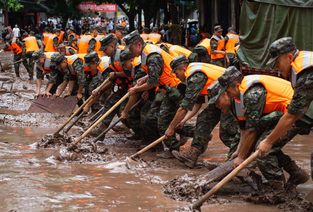 武警重慶總隊執勤第三支隊協助清理街道淤泥。中新社
