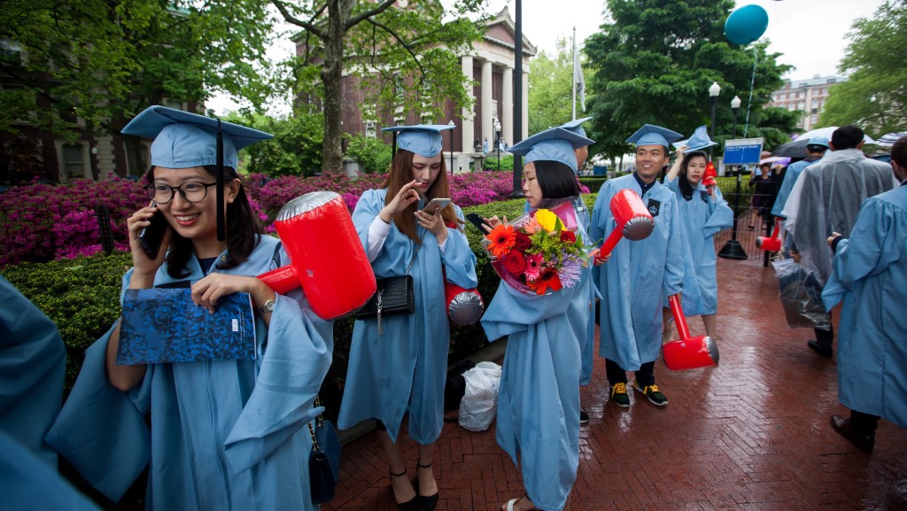 紐約哥倫比亞大學一群華人學生參加畢業禮後急不及待致電家人分享喜悅心情。 新華社