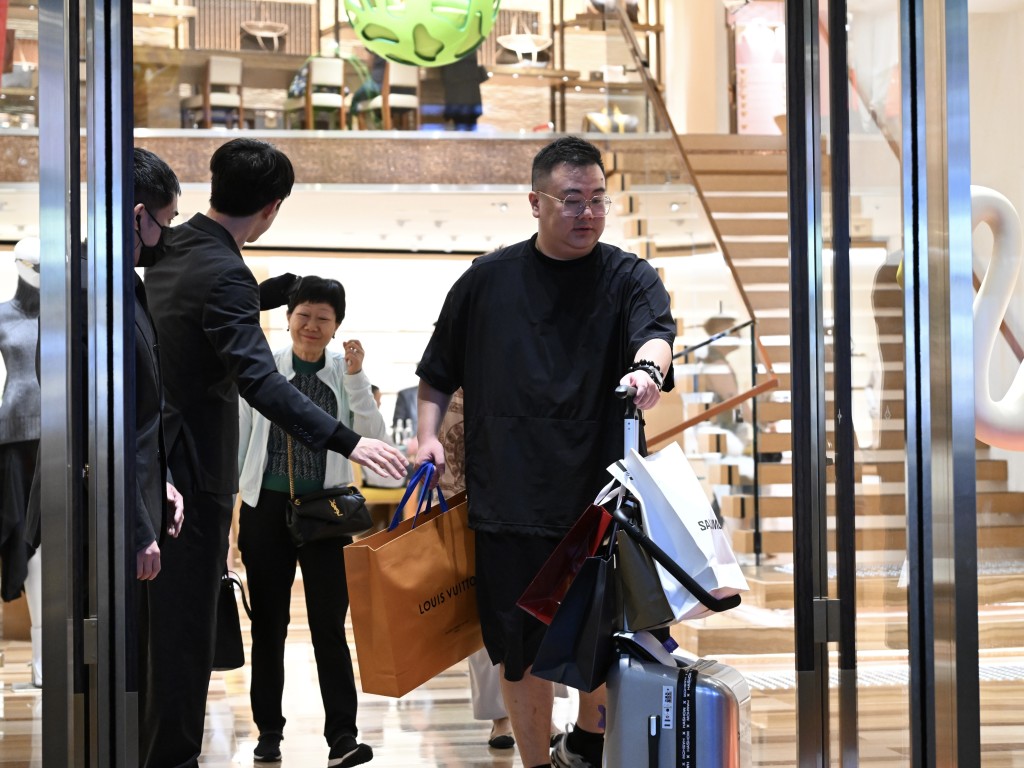 不少旅客在奢侈品店满载而归。钟健华摄