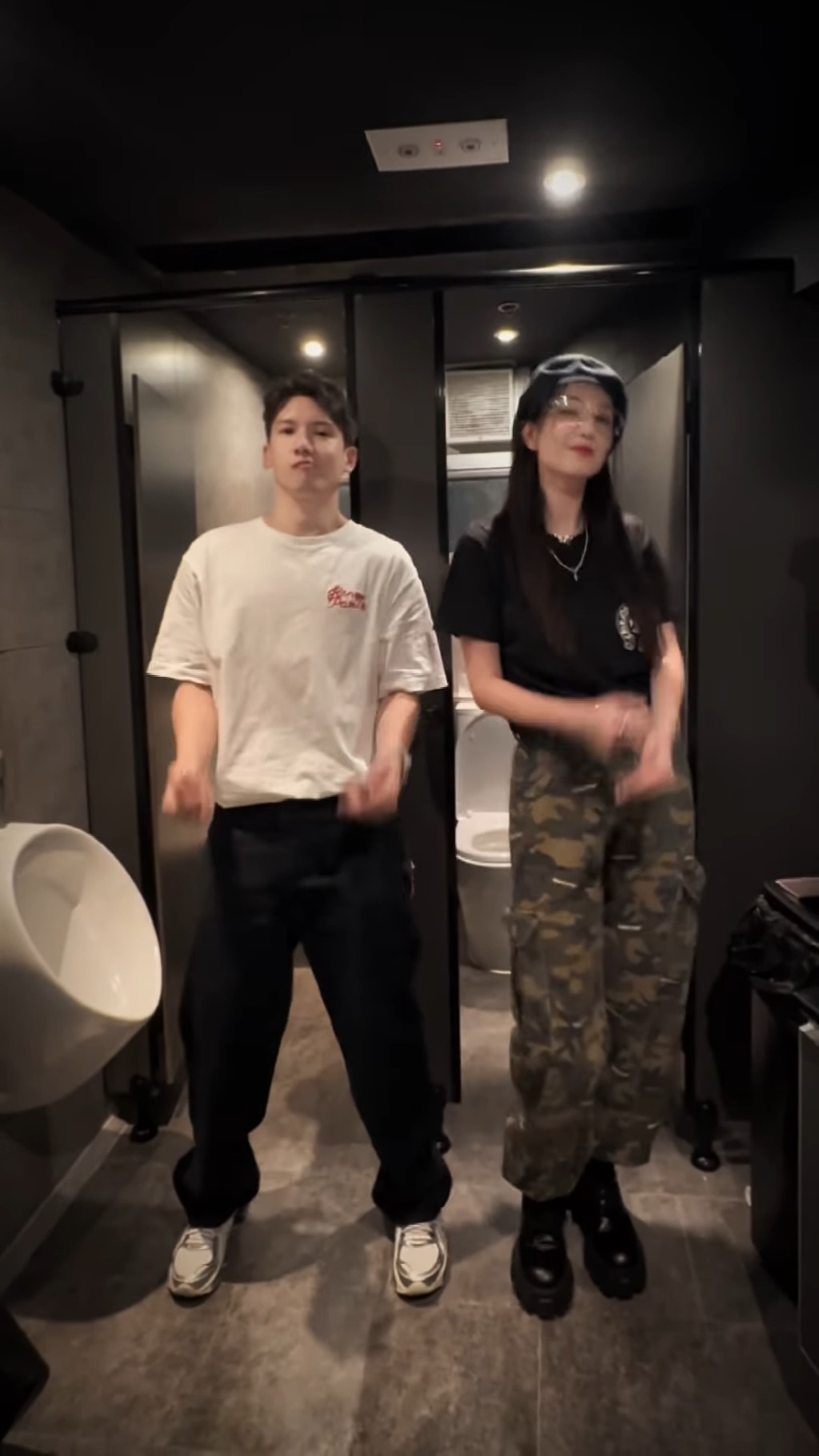 影片中可見關智斌身穿一件樸素的白色T恤配黑色長褲，簡單又不失帥氣。
