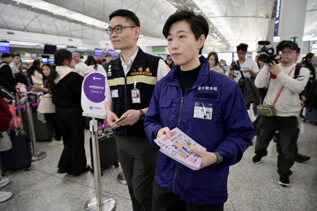 警方聯同入境處在機場派發傳單，提醒出遊市民防騙。蘇正謙攝