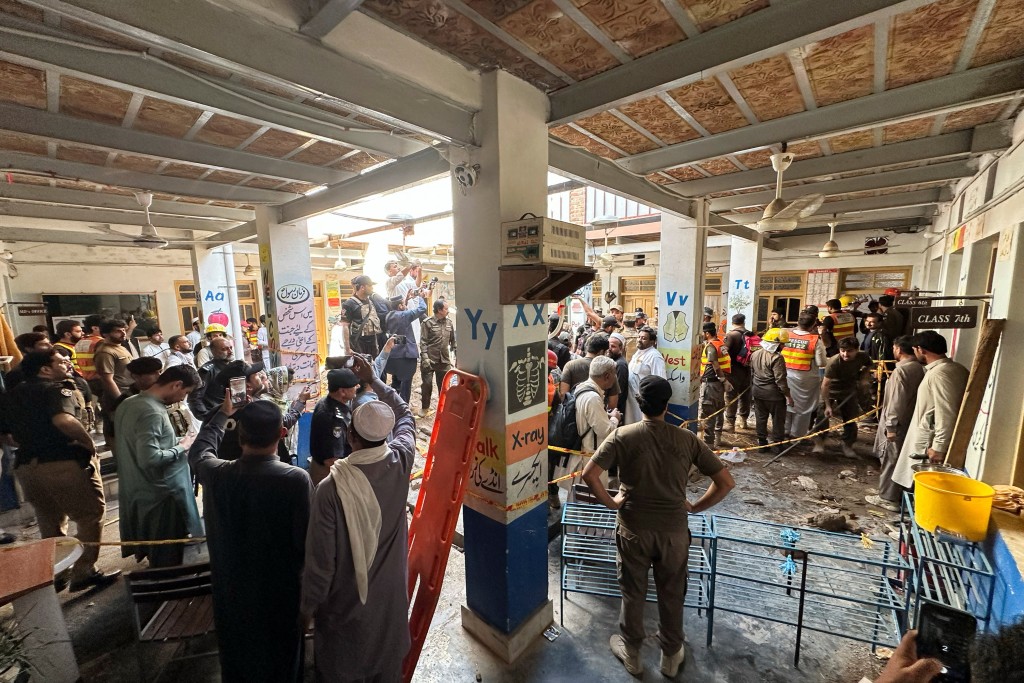 白沙瓦一间学校屋顶坍塌后，家长和居民聚集在救护车附近。路透社