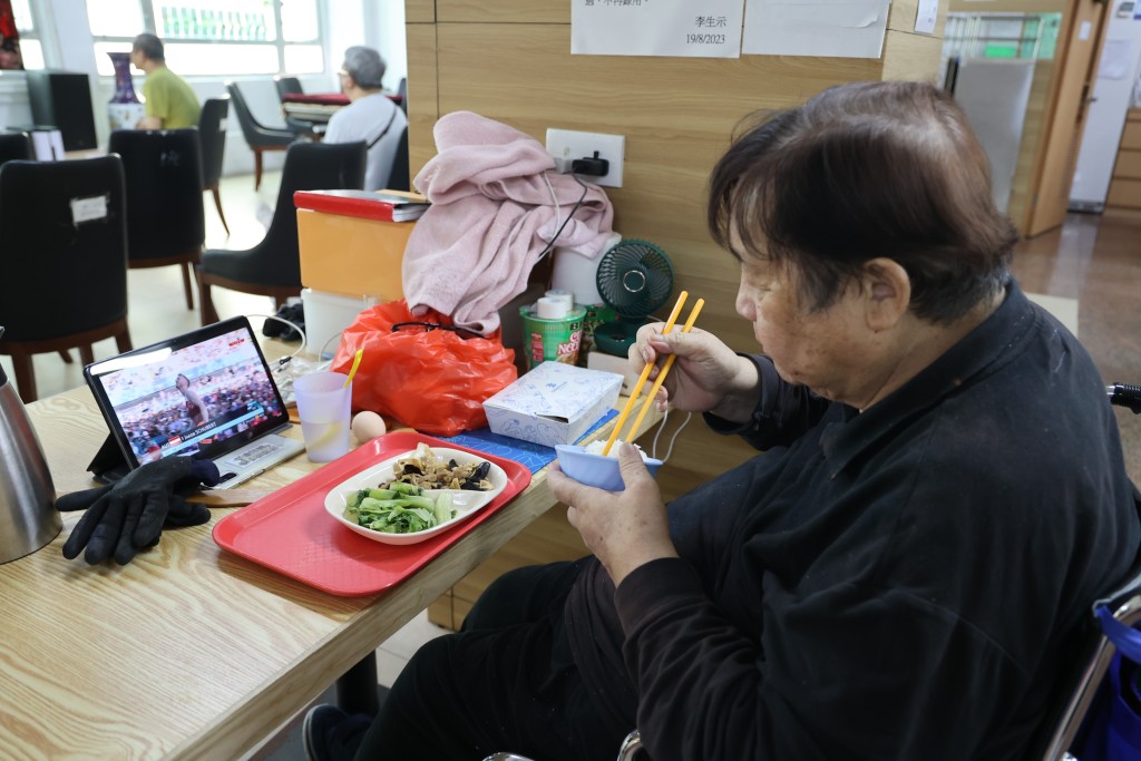 煌哥喺所屬的私人空間，邊食飯邊睇電視。