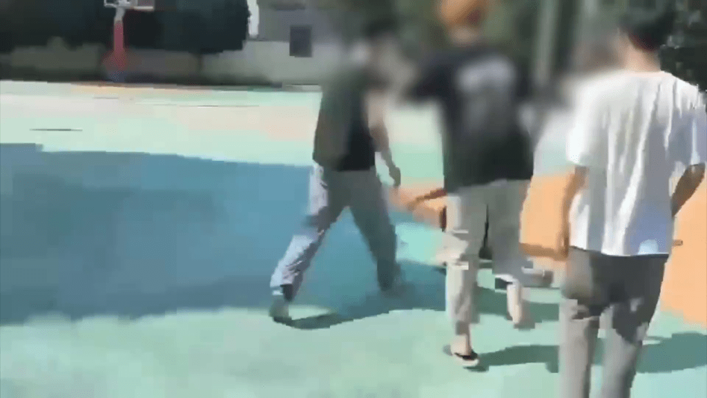 在校内篮球场内，一名学生遭多人围殴。