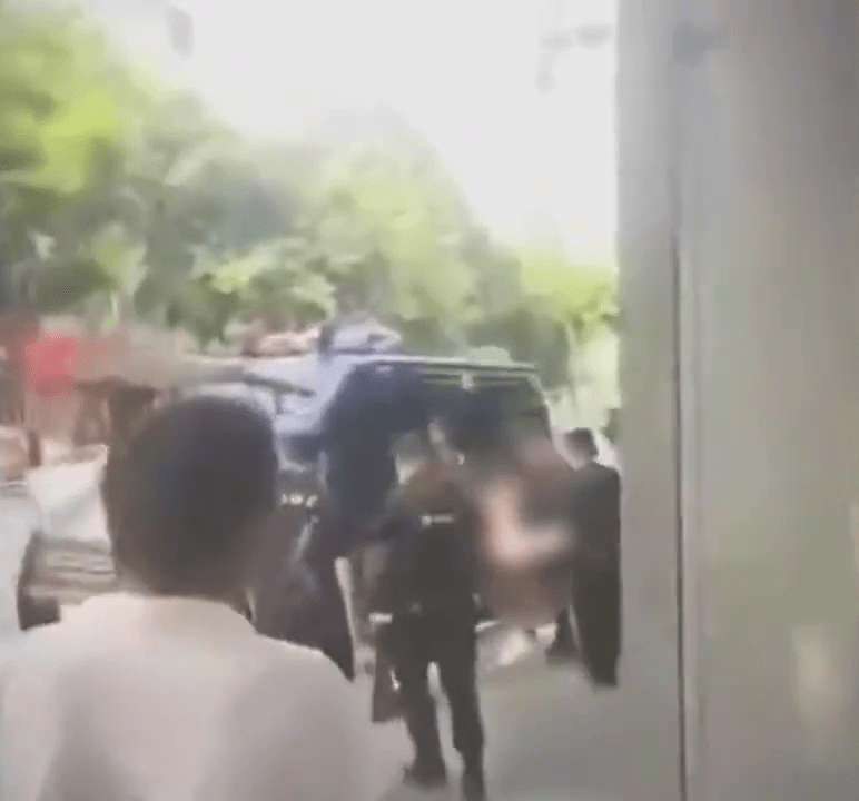 裸跑男被到场的警员押上警车。
