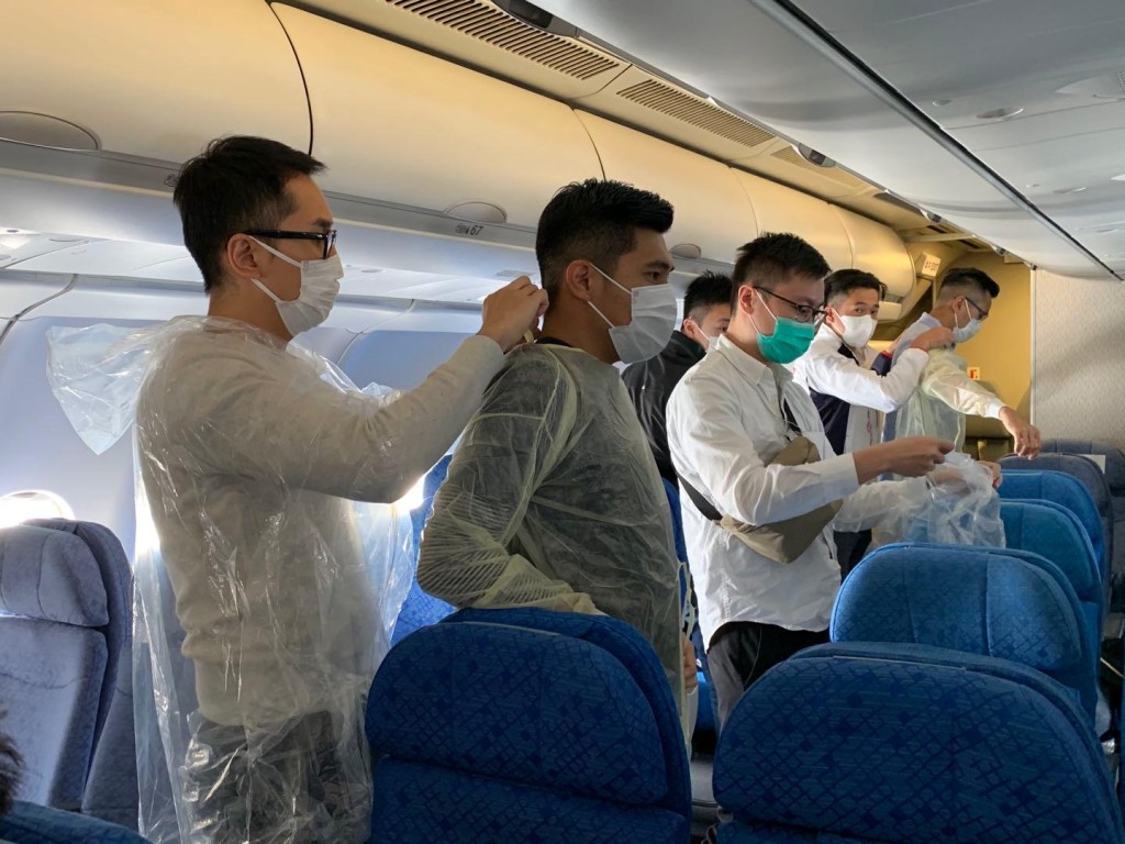 入境處人員落機前互相協助,準備展開撤離行動。