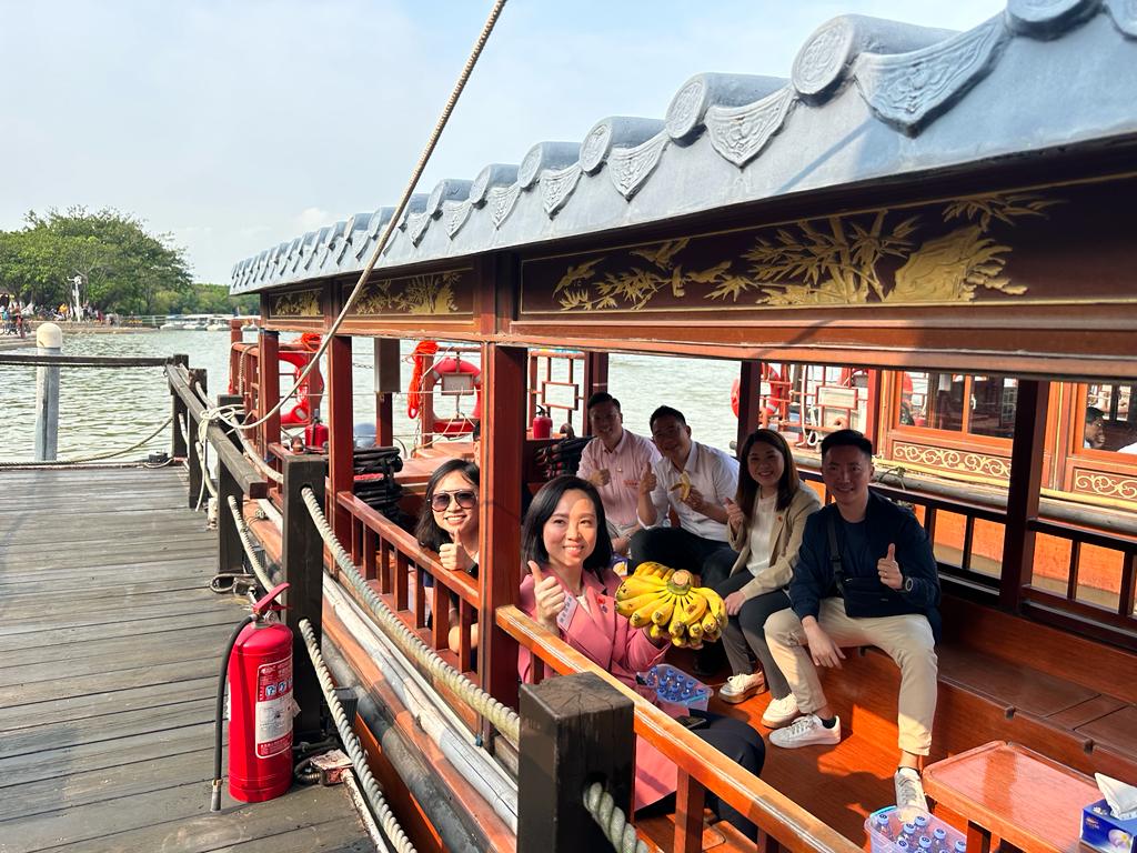 访问团乘上观光船前往鰜鱼洲文创园，他们在船上品尝当地特产「麻涌香蕉」。何嘉敏摄