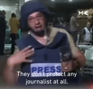 记者脱下身上有「媒体」标志的避弹衣和头盔，说「这东西保护不了我们。」