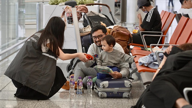 機場「旅客關顧組」向旅客派發樽裝水及玩具畫筆等物資。