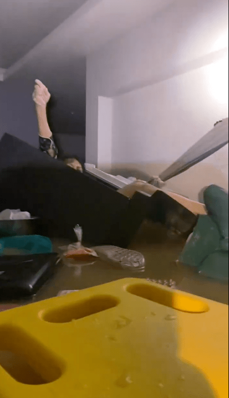 救援人員發現一個漂浮於急流中的冰箱，微弱燈光下，一名年約50歲的婦人虛弱地舉手示意求救。X@Mr_Whathapened