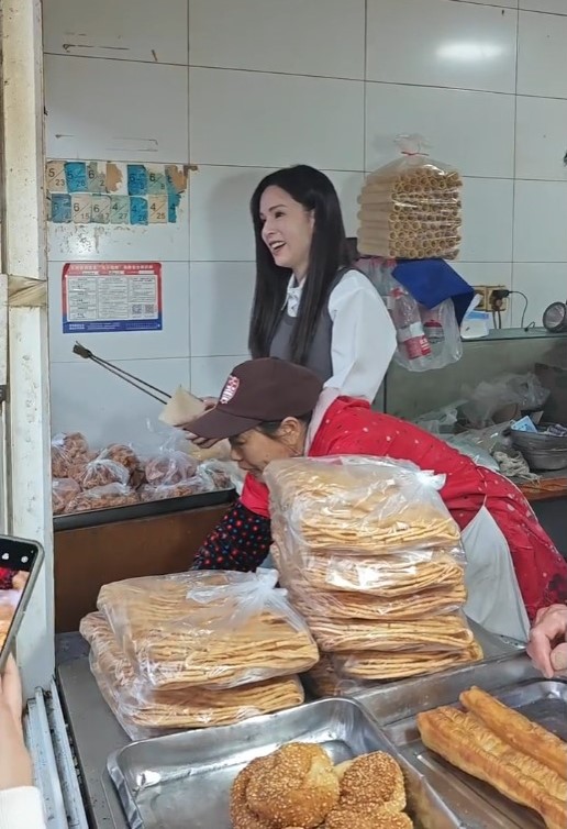 李若彤走到葑门横街一间售卖蛋卷、油条及萝卜丝饼的小食店，充当店员。