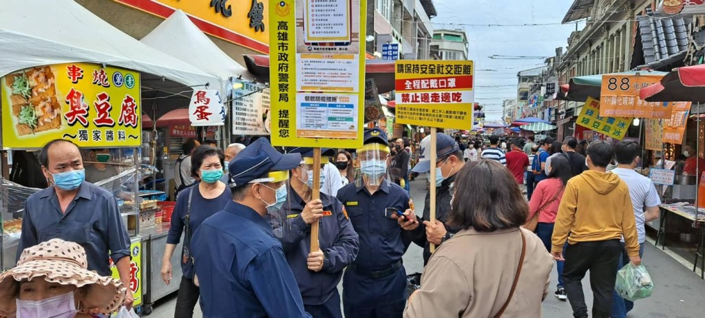 警員在老街舉牌呼籲民眾戴好口罩。旗山警分局fb