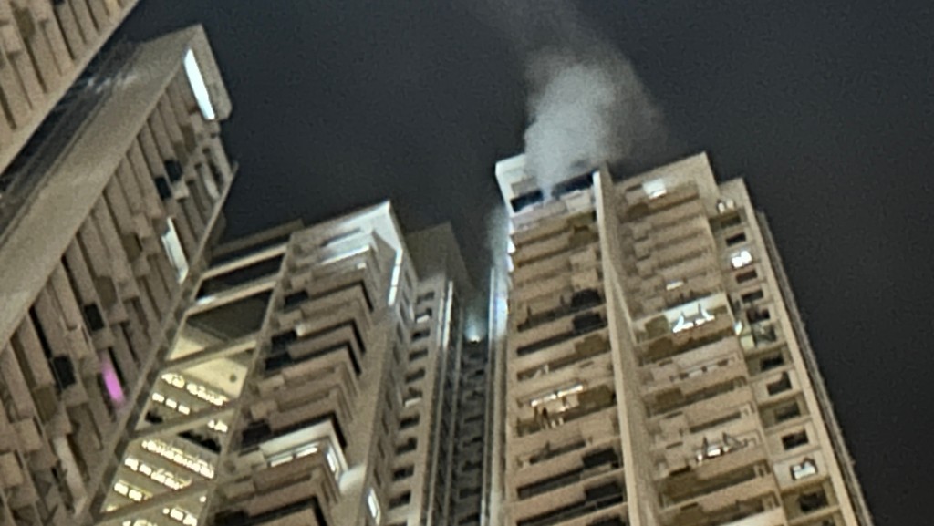 大厦高层有烟冒出。