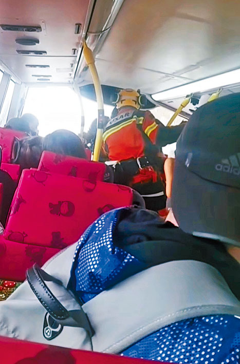 消防員進入巴士上層，將乘客逐一救出。