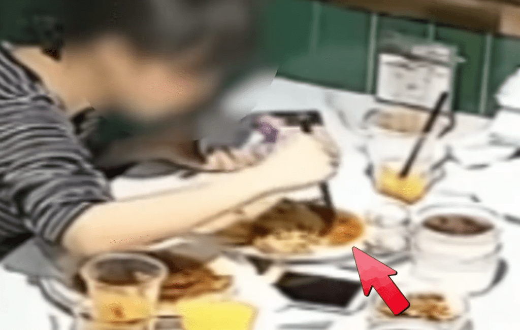 女食客将头发用筷子混入餐食中。