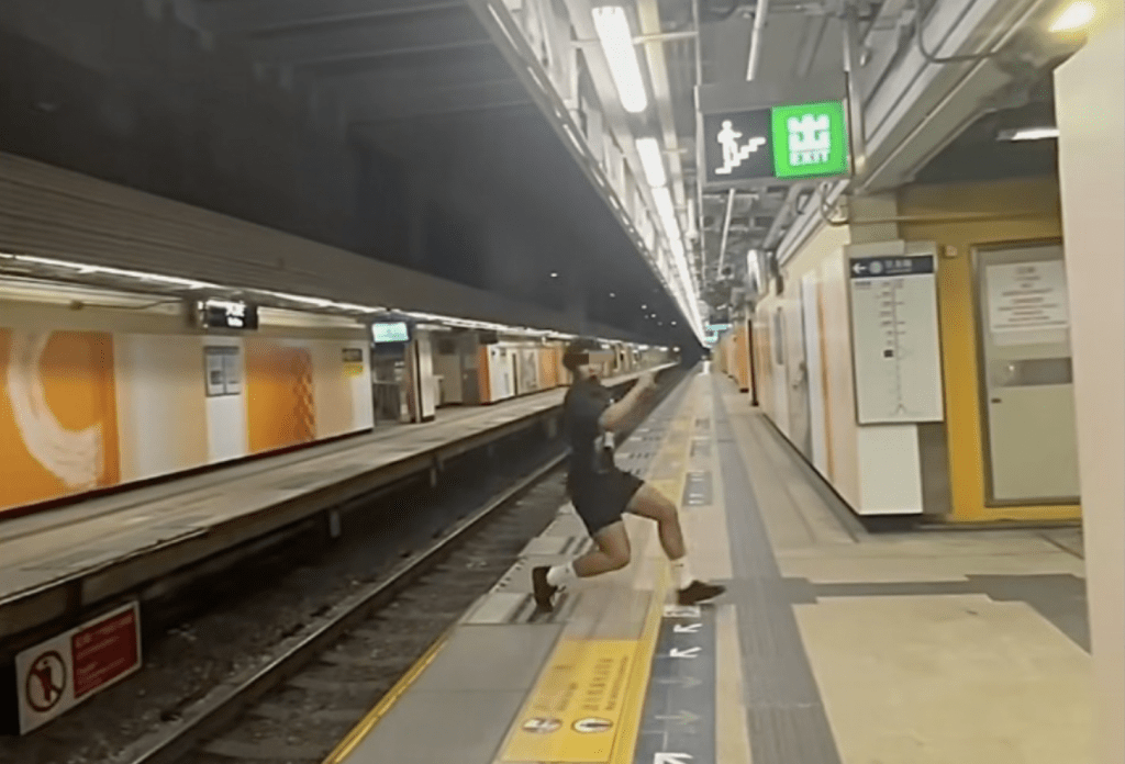 火炭站男子玩“飞跃道” 跳过路轨。网上片段截图