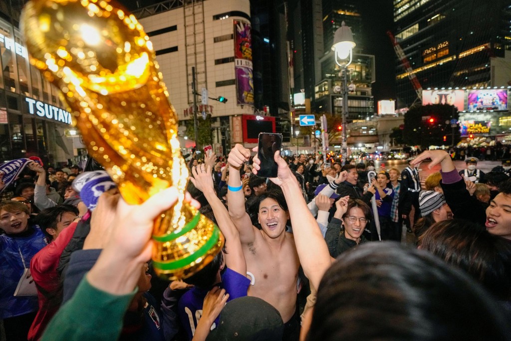 日本球迷在街头高举世界杯。Reuters