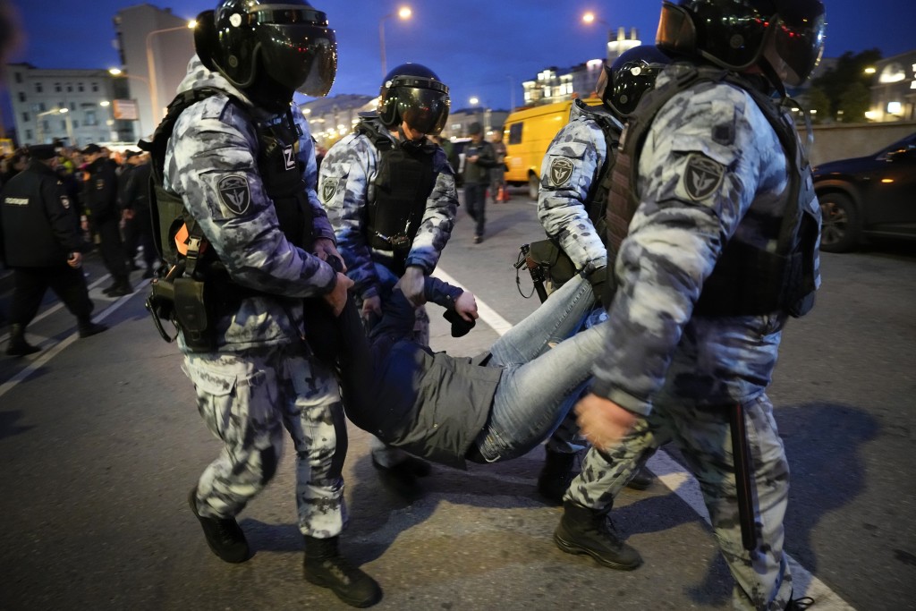 在莫斯科，防暴警察將一名示威者抬走。AP