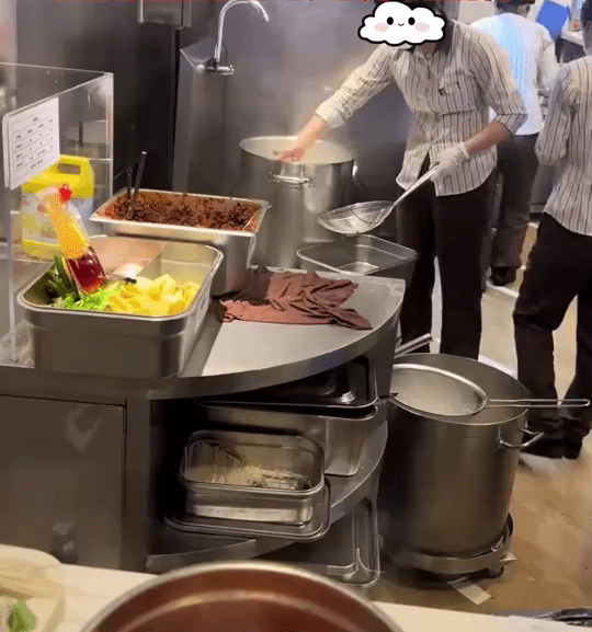 網片顯示，廚房員工用筷子夾起麵條。