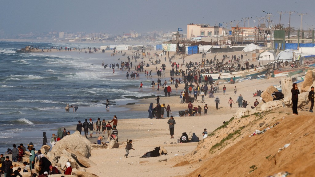 巴勒斯坦人在加沙南部一处海滩聚集，希望能拿到空降物资。 路透社
