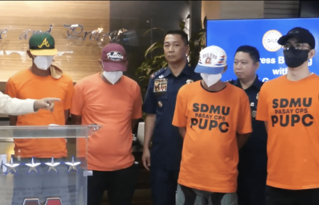 菲律賓警方召開記者會交代案情，圖中4名穿橙衣者為被捕警察。影片截圖